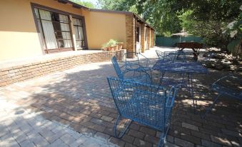 a brick patio with several blue shopping carts and tables , providing seating for people outside at The Guesthouse