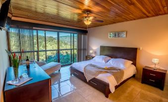 a spacious bedroom with a king - sized bed , hardwood floors , and a view of the mountains at Barons Resort