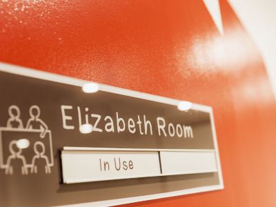 "a close - up of a sign with the name "" elizabeth room "" and an arrow pointing to the user 's name , on a red wall" at Ibis Melbourne Hotel and Apartments