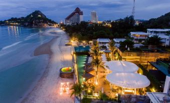 a beach resort at night , with various buildings and people enjoying the view from the top of the building at The Yana Villas Hua Hin