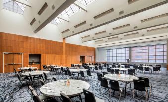 a large , empty banquet hall with multiple round tables and chairs arranged for a meeting or event at W Hoboken