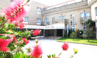 "a hotel with a red flower garden in front and the words "" hotel park "" on it" at Hotel Park