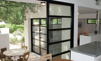 a modern kitchen with black doors , wooden tables , and chairs , as well as a dining area at Holiday Home Villa Isabelle