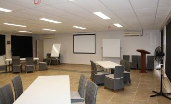 a large , empty room with white tables and chairs set up for an event or meeting at Saletoga Sands Resort & Spa