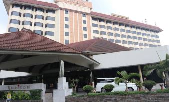 a hotel with a large building and a white car parked in front of it at Horison Ultima Bandung