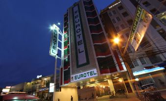 "a tall building with a sign that says "" eurotel "" is lit up at night" at Eurotel Angeles