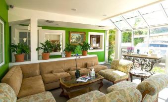 a large living room with a couch , chairs , and a coffee table in front of a window at Malibu Country Inn