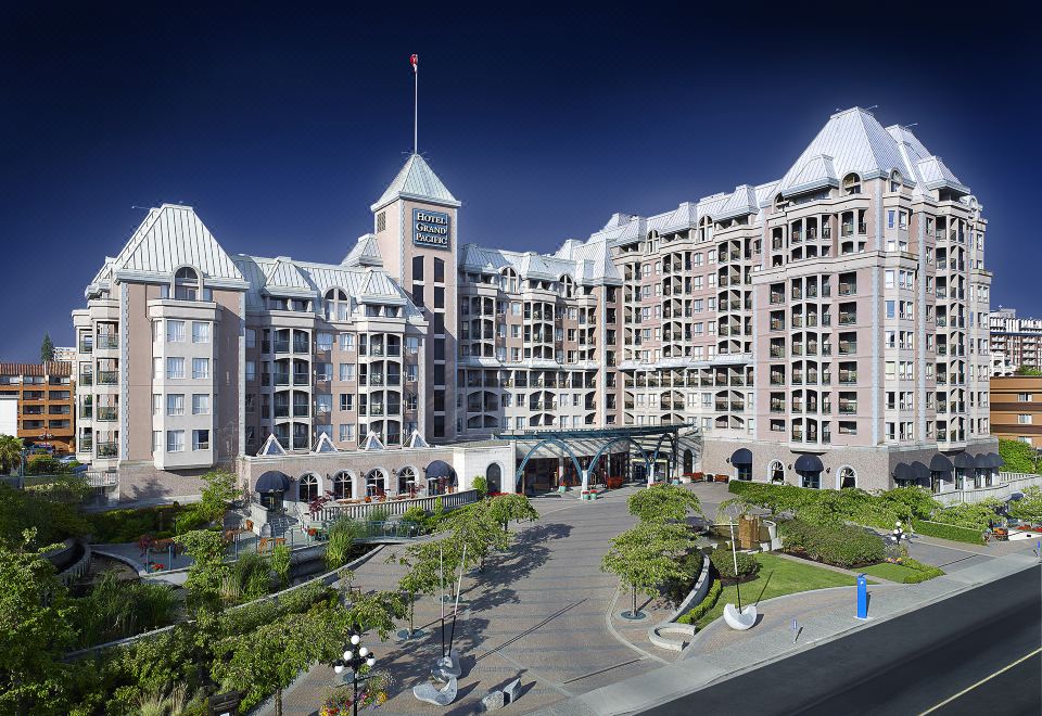 a large , modern hotel building with multiple floors and a parking lot in front of it at Hotel Grand Pacific