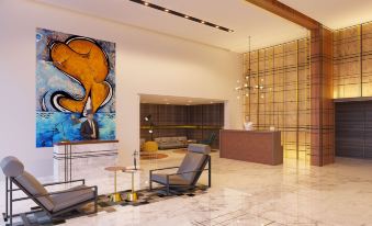 a modern hotel lobby with a marble floor , an art piece on the wall , and a reception desk at Le Méridien Goa, Calangute