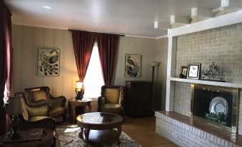 a cozy living room with two chairs , a fireplace , and a couch , creating a warm and inviting atmosphere at Sassafras Inn