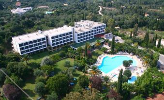 aerial view of a large hotel surrounded by trees and a swimming pool , located in a mountainous area at Park