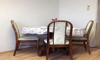 a dining room with a wooden table and four chairs , along with a clock on the wall at Bike Apartment