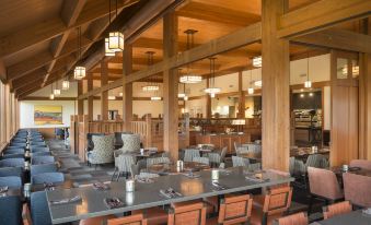 a large , open dining room with wooden tables and chairs arranged for a group of people at Skamania Lodge