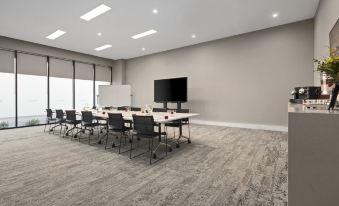 a large conference room with multiple chairs arranged in a semicircle around a long table at Quest Innaloo