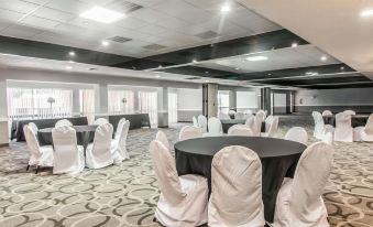 a large conference room with round tables and chairs arranged for a meeting or event at Quality Inn and Suites Conference Center