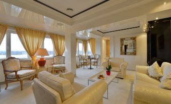 a spacious living room with white walls , hardwood floors , and beige furniture arranged around a coffee table at The Monarch Hotel