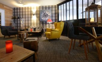 a living room with various furniture , including a couch , chairs , and a dining table , as well as a clock on the wall at Hotel Panorama