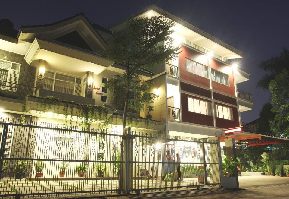 a residential building with a fenced - in area , and a person standing in front of it at Super OYO Collection O Sweet Karina Bandung