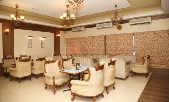 a room with several chairs and couches arranged in a circle , creating a cozy atmosphere at Moti Mahal