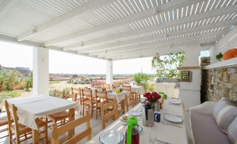 a dining area with tables and chairs arranged for a group of people to enjoy a meal at Natura Villas in Naxos