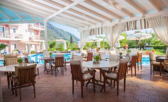 an outdoor dining area with a pool view , surrounded by chairs and tables , and umbrellas providing shade at G George