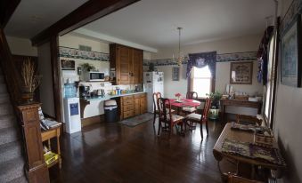 a large kitchen with wooden floors and a dining area with chairs and a table at Country View PA Bed & Breakfast