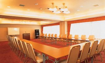 a large conference room with multiple rows of chairs arranged in a semicircle around a long table at Courtyard by Marriott Hakuba