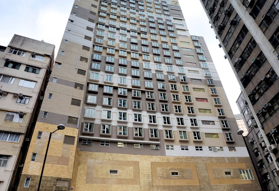 The center for skyscrapers is a large building with many windows and an umbrella in front at Ramada Hong Kong Grand