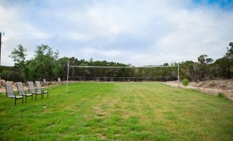 a grassy field with a volleyball net set up in the middle , ready for a game at Hill Country Casitas