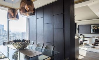 a modern dining room with a glass dining table and chairs , surrounded by a black wall at Icon Hotel