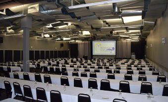 an empty conference room with rows of chairs and a projector screen , ready for a meeting or event at Metropolis Resort - Eau Claire