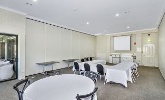 a conference room set up for a meeting , with tables and chairs arranged in a semicircle at Bayswater Tweed