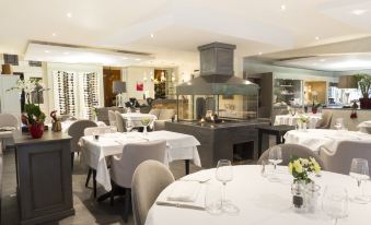 a well - decorated dining room with tables and chairs arranged for a group of people to enjoy a meal together at La Residence - Logis de France