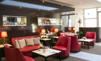 a modern , well - lit restaurant with red and white couches , chairs , tables , and potted plants on the walls at Hôtel Mercure Chartres Centre Cathédrale