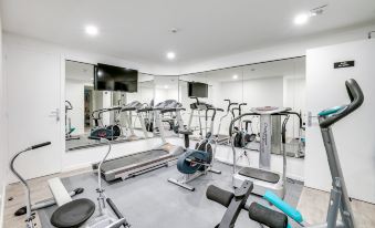 a well - equipped gym with a variety of exercise equipment , including treadmills , weight machines , and benches at Paris Hotel