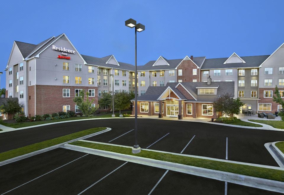 a large hotel with a parking lot in front of it , illuminated at night at Residence Inn Waldorf