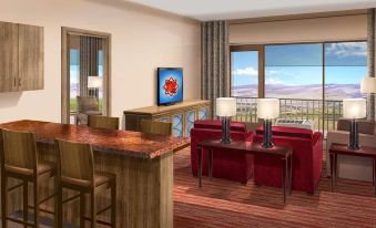 a 3 d rendering of a modern living room with red furniture and large windows offering views of the city at Shoshone Rose Casino & Hotel