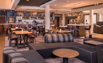 a modern restaurant with a bar and dining area , featuring a variety of seating options for guests at Sonesta Select Columbia