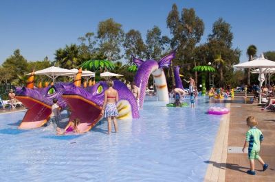 a large pool filled with water and surrounded by people , some of whom are playing in the water at Club Mac Club Mac - All Inclusive Family Resort Photo