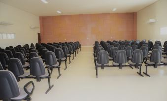 a large conference room with rows of black chairs arranged in a semicircle , ready for a meeting or presentation at Bristol Aline