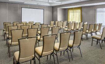 a conference room with rows of chairs arranged in a semicircle , ready for a meeting or presentation at SpringHill Suites Long Island Brookhaven