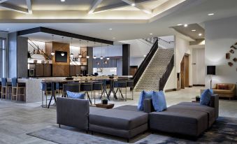 a modern lounge area with couches , chairs , and a dining table in a spacious room at Marriott Dallas Las Colinas