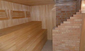 a wooden room with a brick wall and a staircase leading to an upper level at Yugorsky