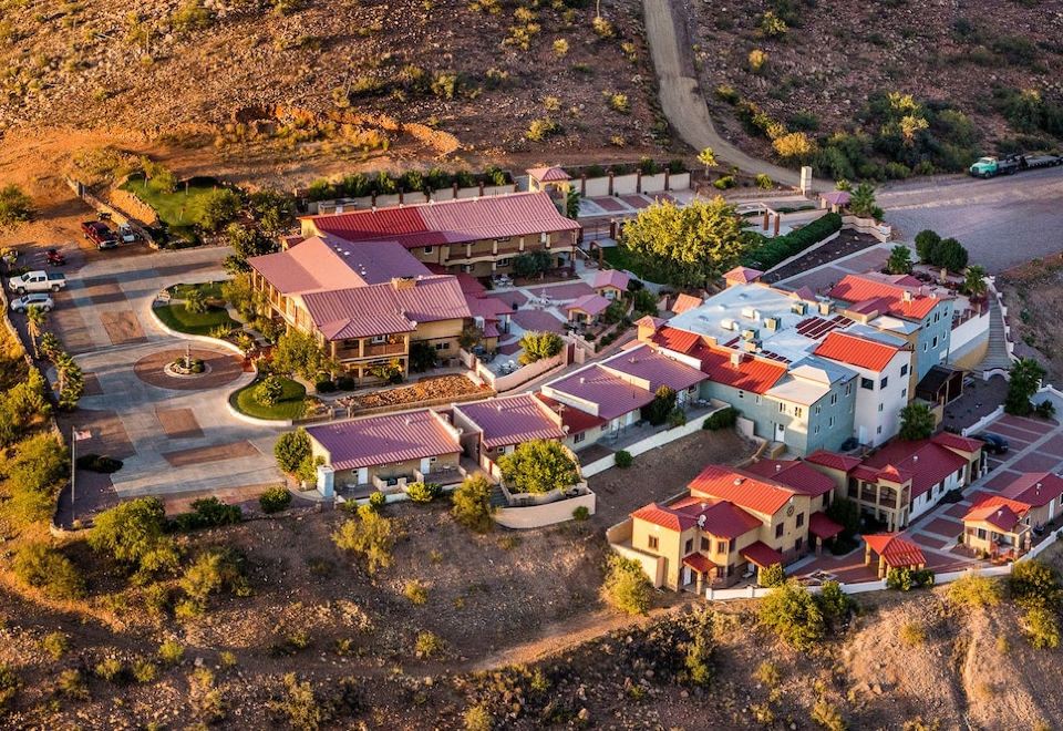 an aerial view of a residential area with multiple houses , trees , and mountains in the background at Dream Manor Inn