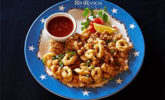 a plate of food with fried shrimp and a side of sauce on a blue and white plate at Hilton Houston Westchase