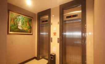 a modern elevator in a building , with two elevators and a painting on the wall at Valdos Hotel Manokwari