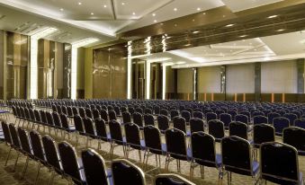 a large conference room with rows of chairs arranged in a semicircle , and a podium at the front of the room at Novotel Bangka - Hotel & Convention Centre