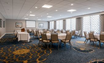 a large conference room with multiple tables and chairs arranged for a meeting or event at Holiday Inn South Kingstown (Newport Area)