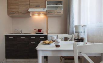 a kitchen with a white table and chairs , a coffee maker , and a microwave on the counter at Sofi