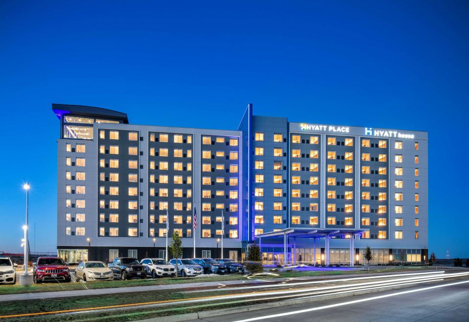 a large , modern hotel building with a blue and white color scheme , located in a city setting at Hyatt Place East Moline/Quad Cities